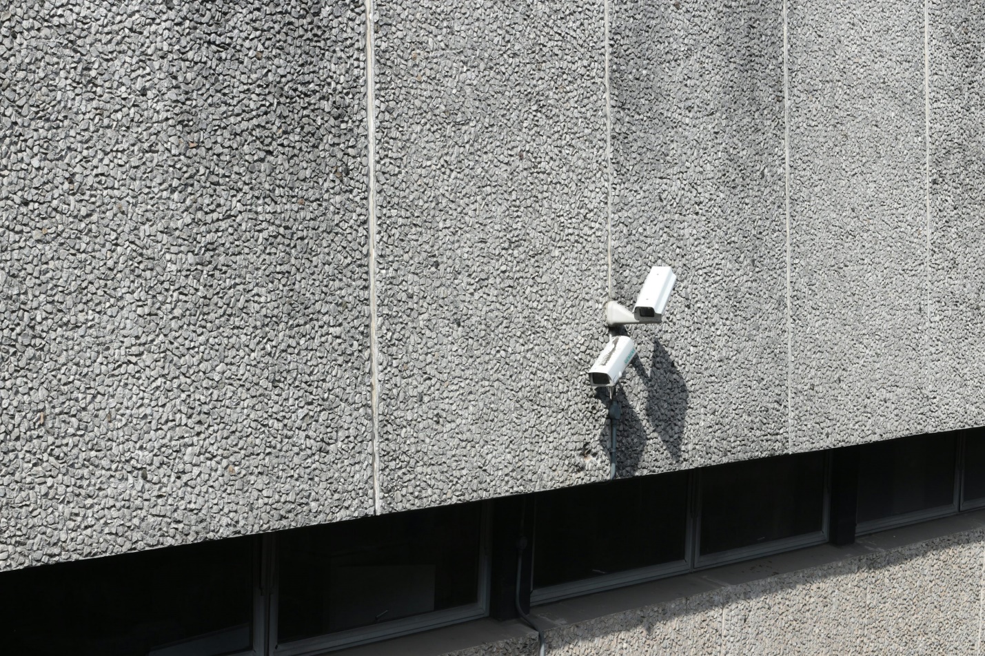 Two cameras on a gray wall as part of a home security camera installation 