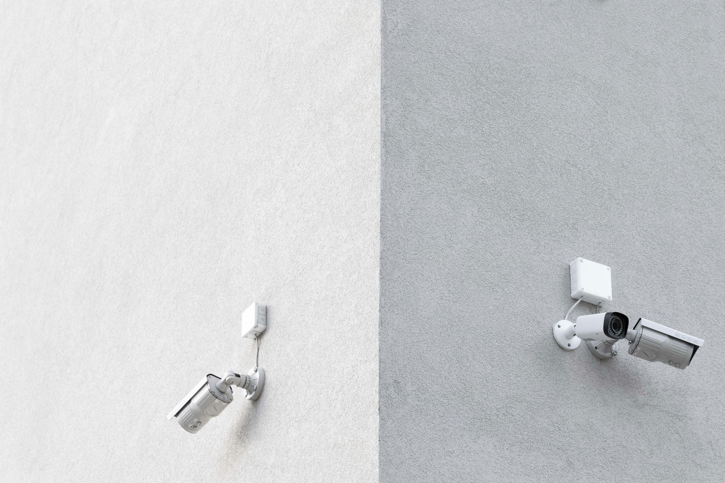 Two cameras on a gray wall as part of a home security camera installation 