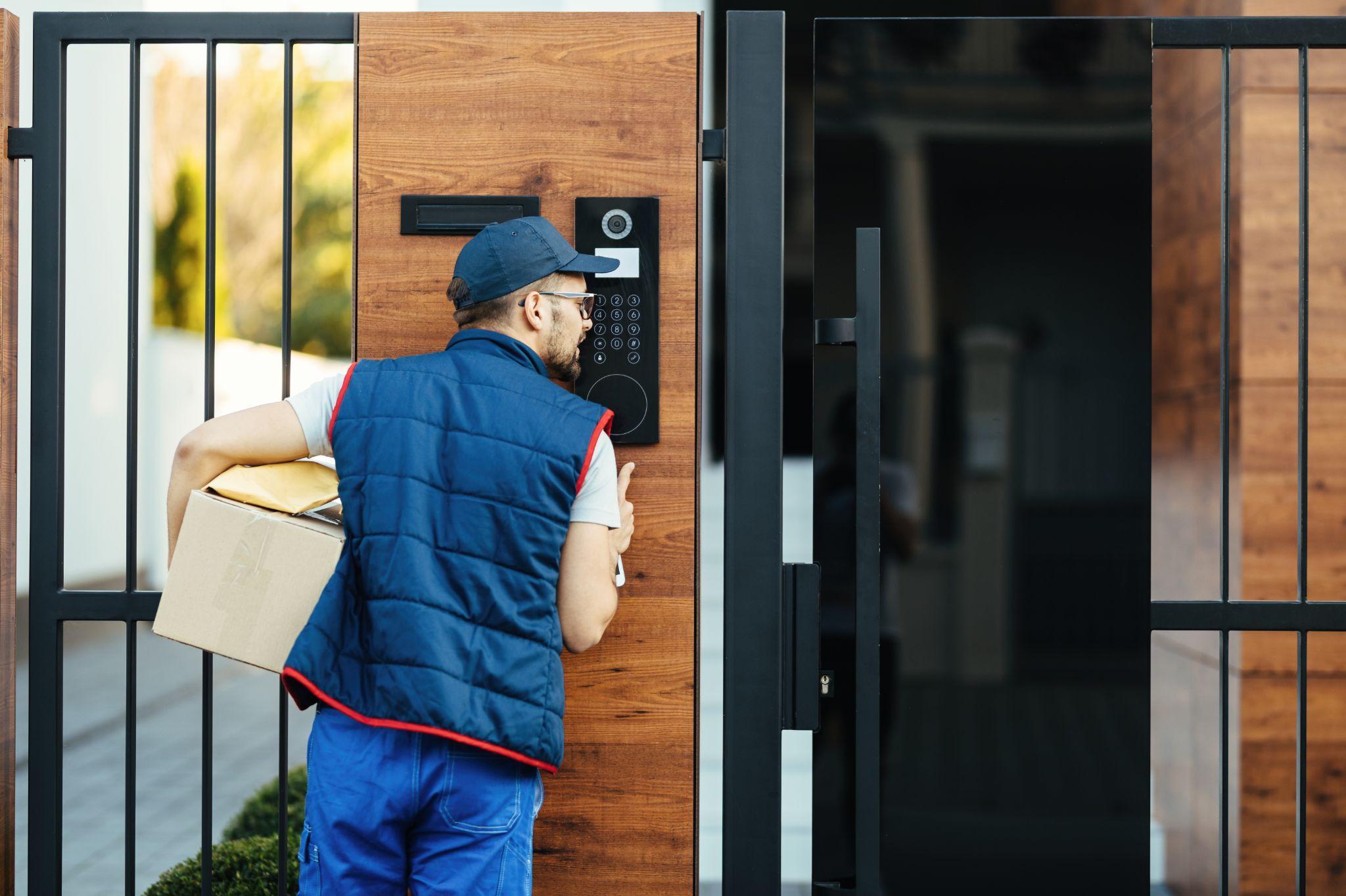 A delivery man speaking into an intercom system from outside.