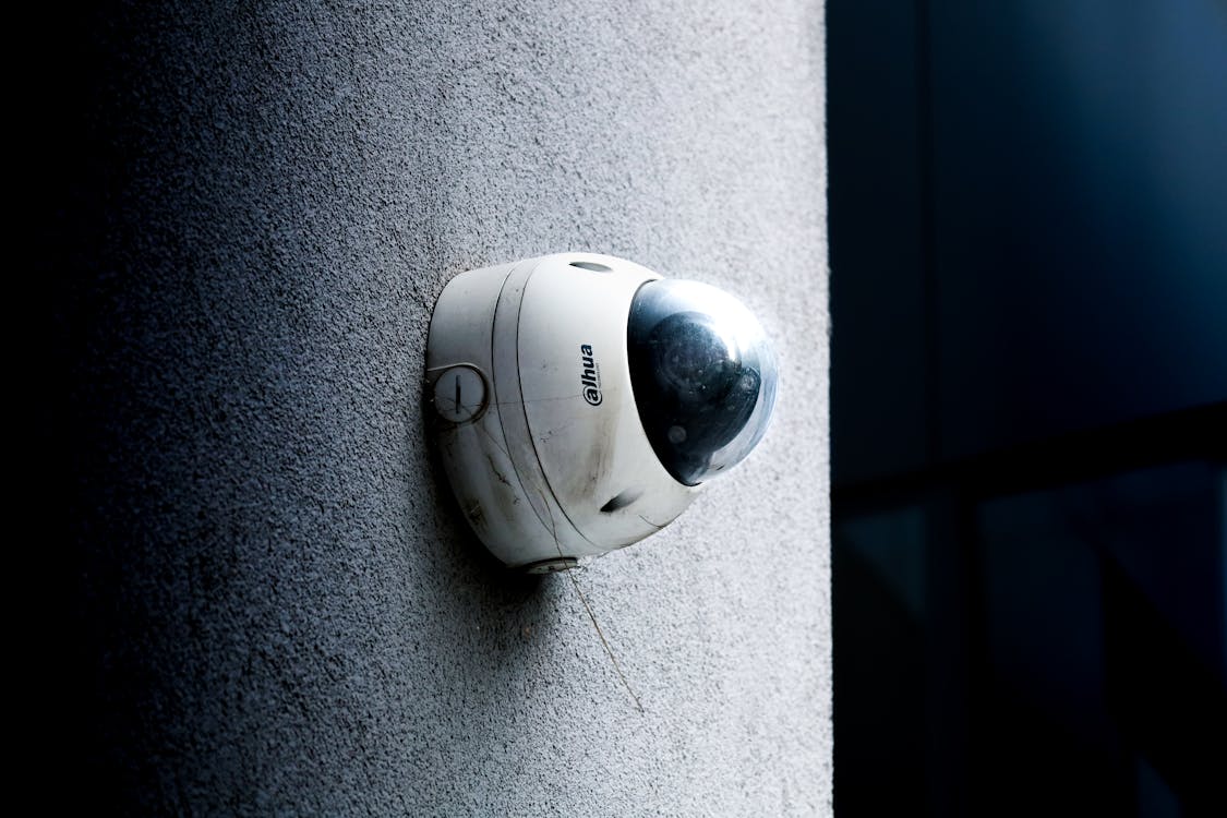 An outdoor security camera mounted on a concrete wall, ensuring the protection of outdoor spaces.