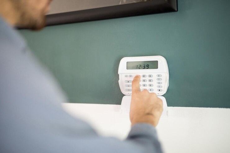 Close-up of a man using a keypad to operate his home alarm system.