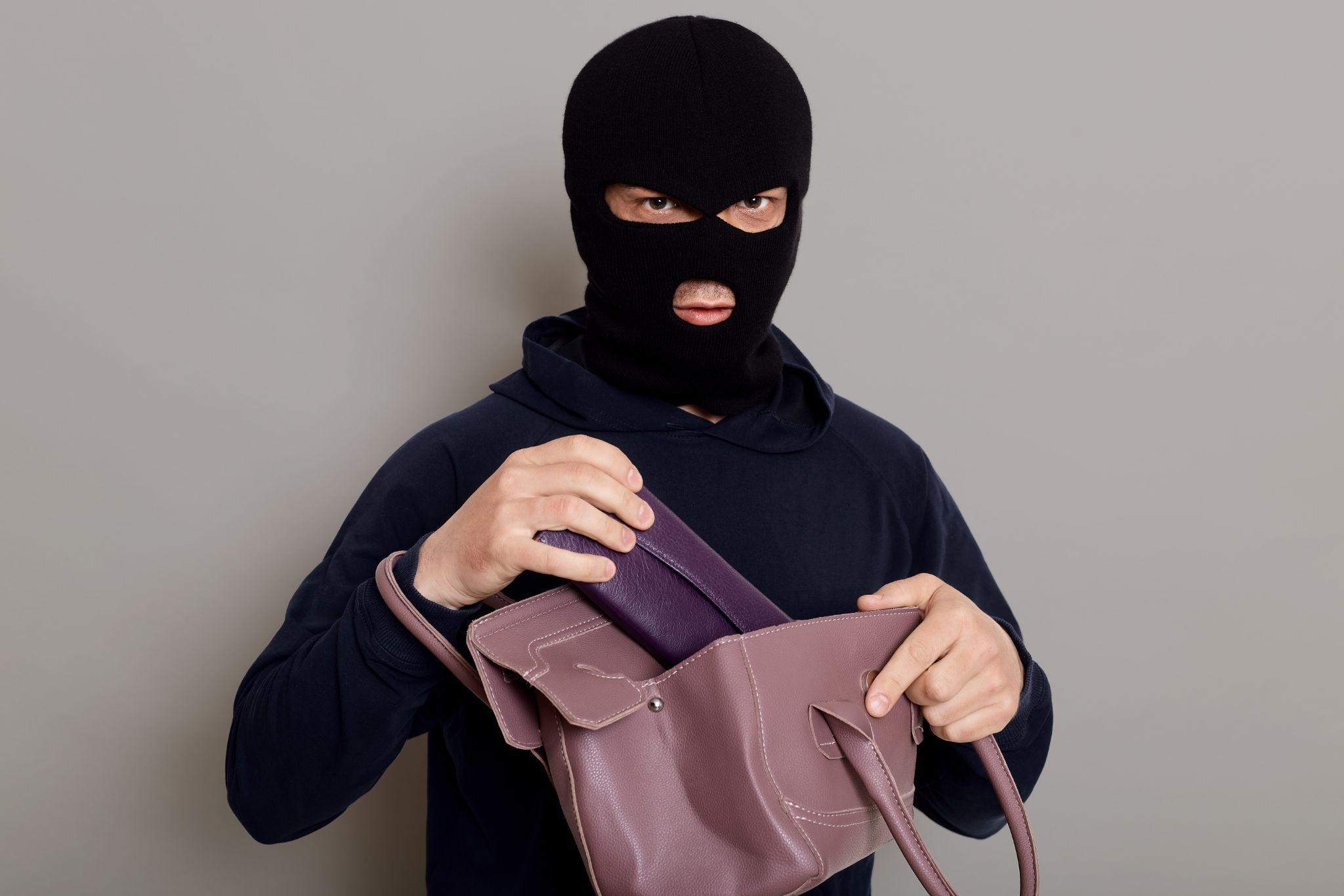 A masked individual committing a robbery