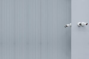Multiple CCTV cameras mounted on a white wall