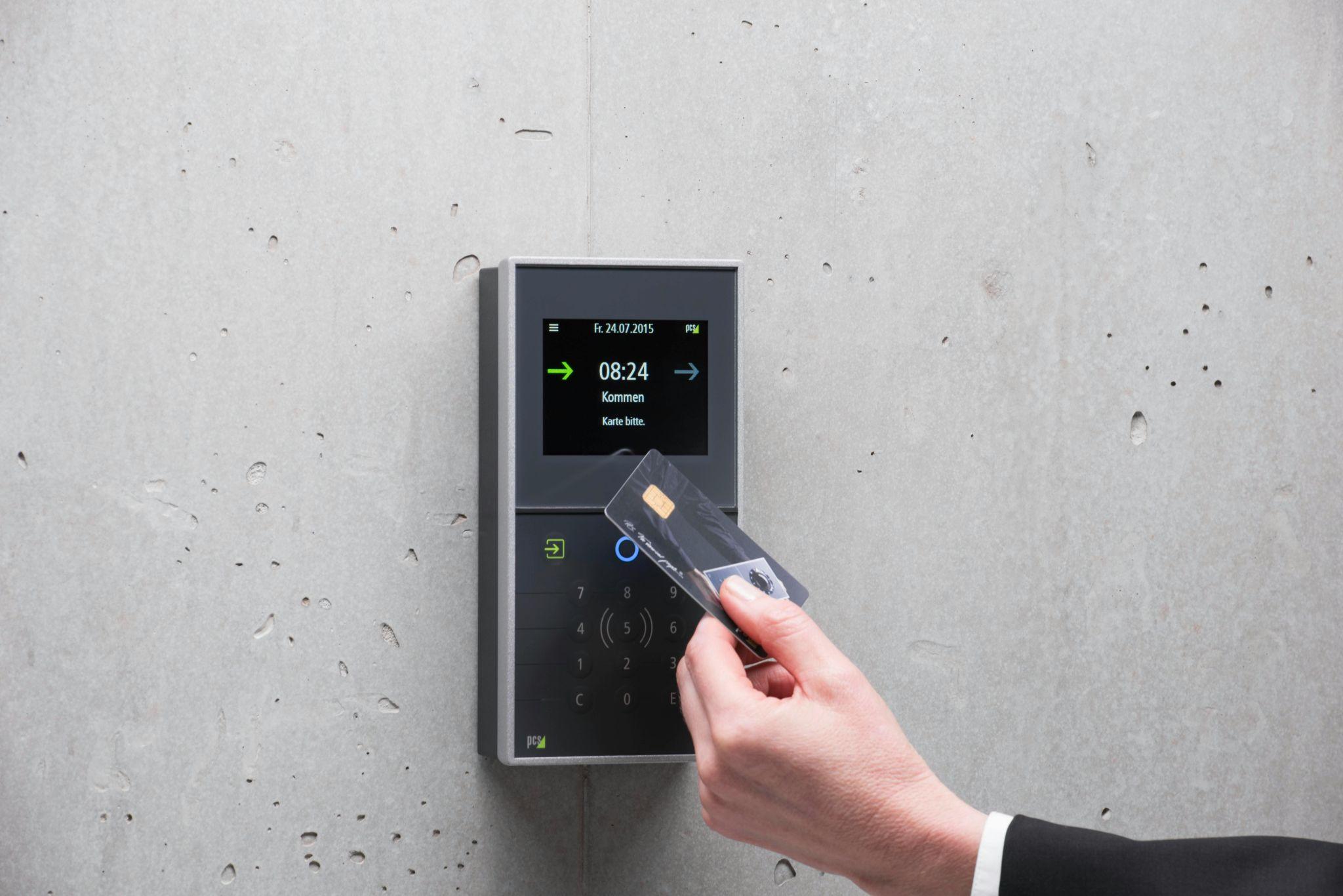 A person scanning a card on an access control system for entry.