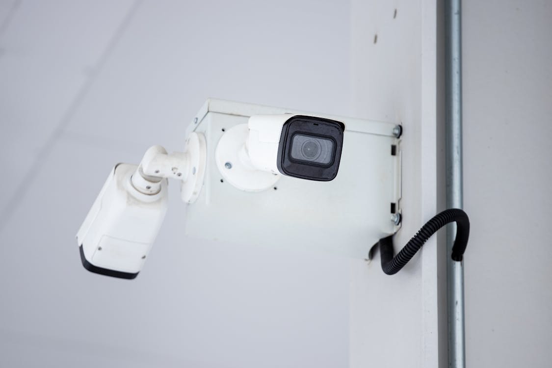 A mounted surveillance camera on the wall, symbolizing the importance of proper camera placement for maximum security.