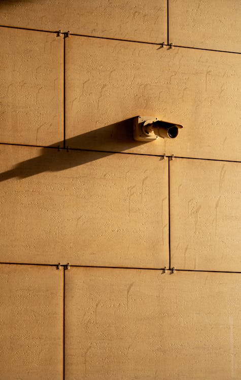 A close-up of a CCTV camera mounted on a concrete wall, emphasizing the need for strategic placement in security systems.