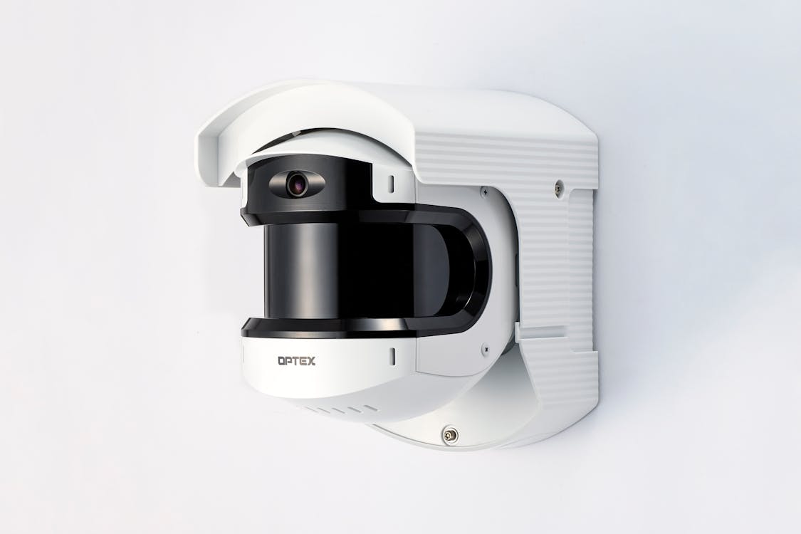 A security camera mounted on a white wall, highlighting modern surveillance technology for businesses.