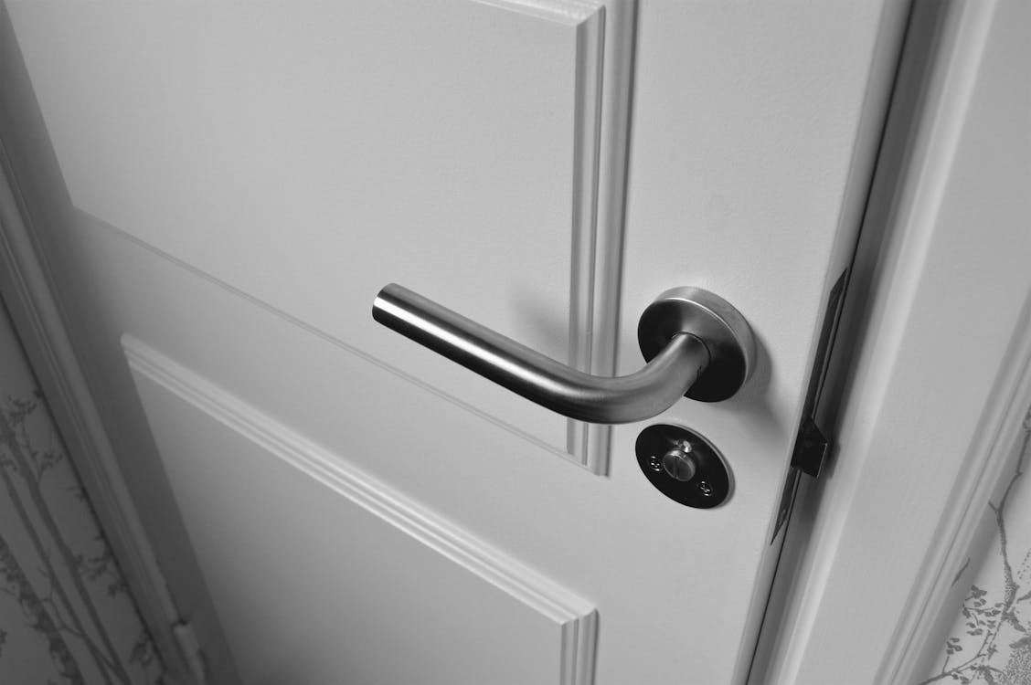 A semi-open wooden door, representing the vulnerability of entry points in homes and the need for advanced smart security systems.