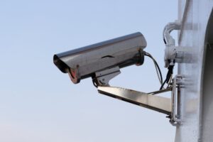 A silver security camera, representing the key role of surveillance systems in securing small businesses.
