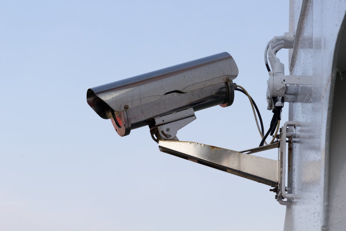 A silver security camera, representing the key role of surveillance systems in securing small businesses.