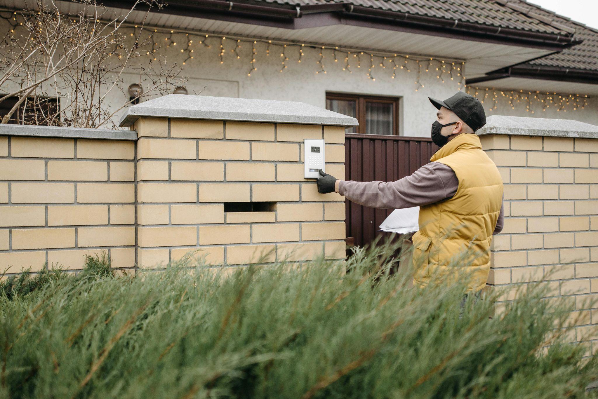 A visitor pressing a button on a modern intercom system
