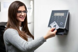 A woman using a card-based access control system for secure entry.