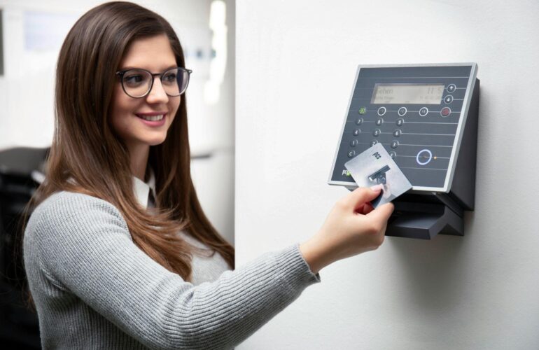 A woman using a card-based access control system for secure entry.